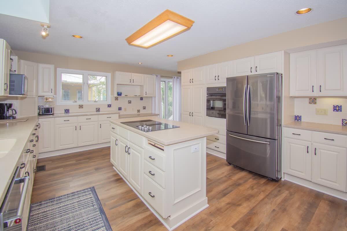 Kitchen with Updated Appliances, Including a Wall Oven and Two Islands, One With a Built-In Cooktop.