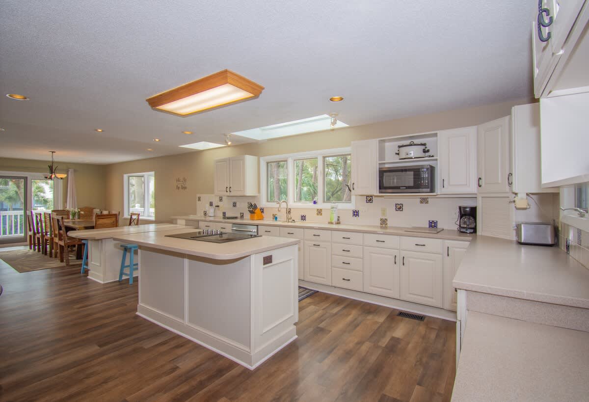 Kitchen with Updated Appliances, Including a Wall Oven and Two Islands, One With a Built-In Cooktop.