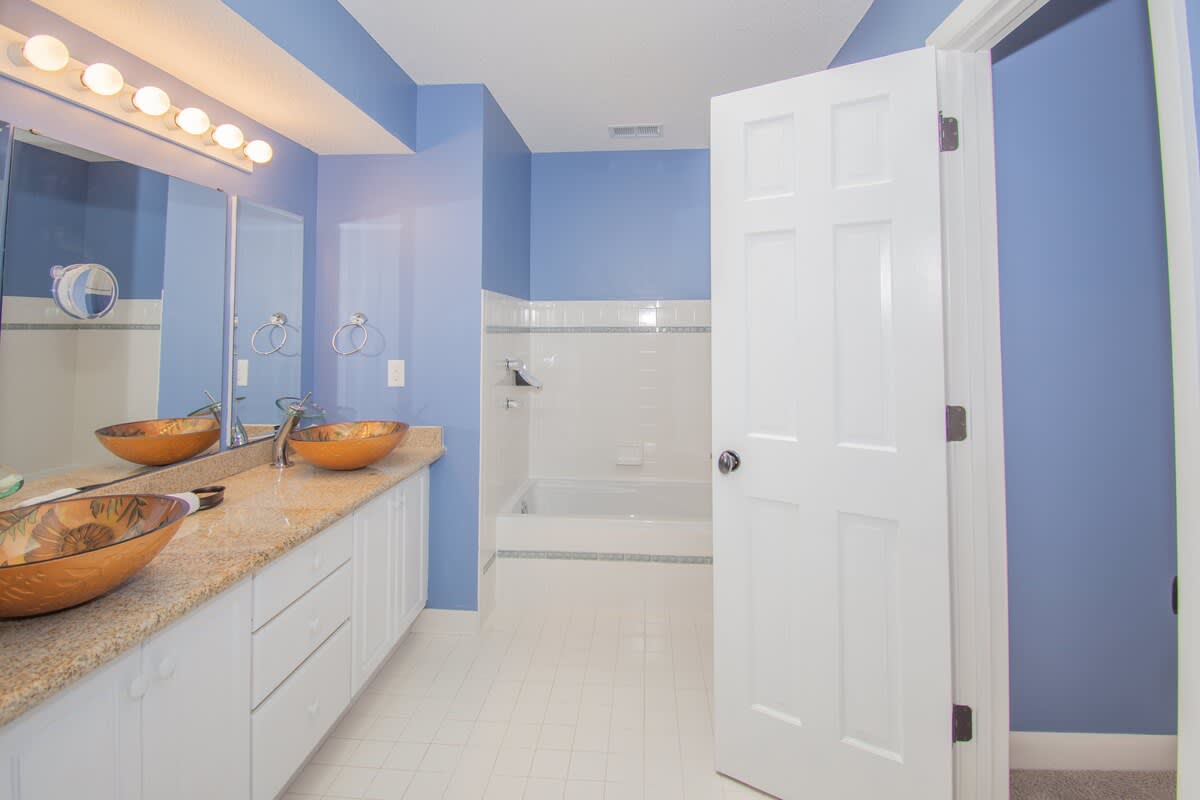 Guest Bedroom Ensuite with Double Vanity, Walk-In Shower, and Tub