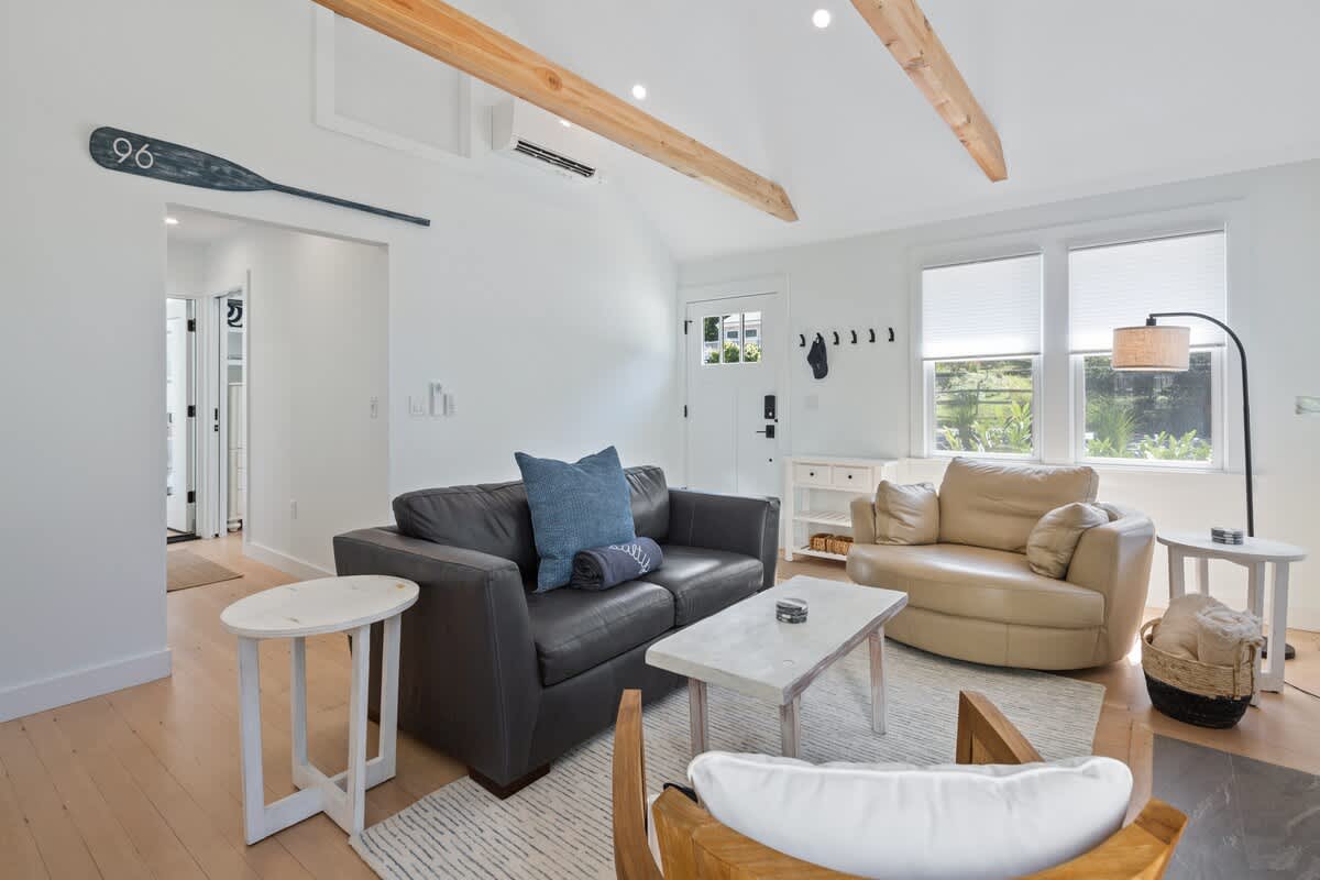 The room boasts cozy seating, vaulted ceilings, and gorgeous wooden beams