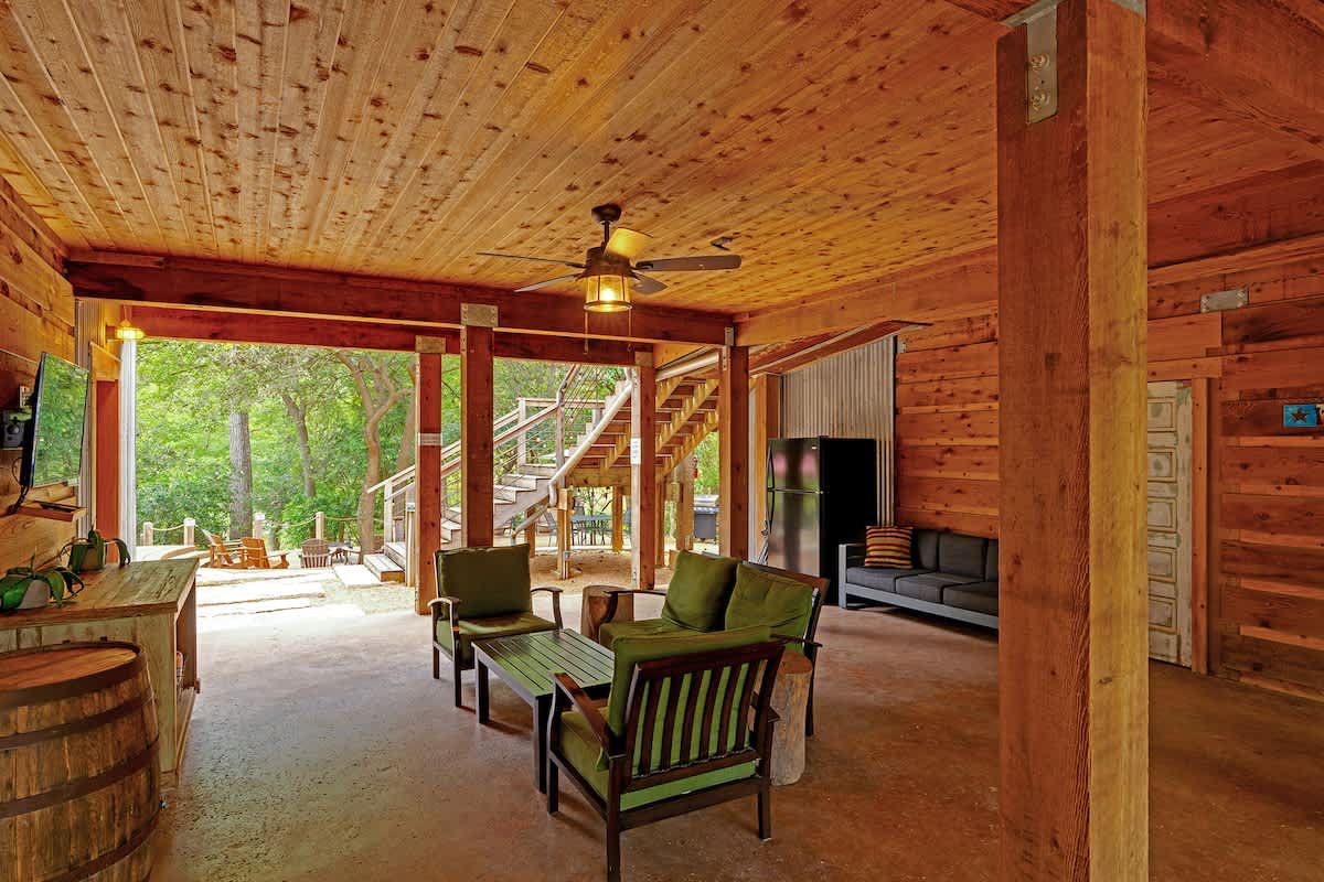 Covered patio with seating TV and full fridge.