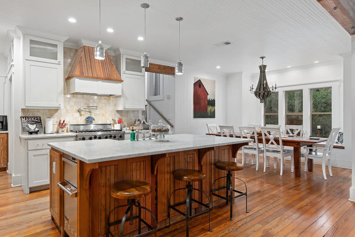 Spacious kitchen with a charming farmhouse sink, gleaming stainless steel appliances, and a gas stove fit for cooking up big feasts.