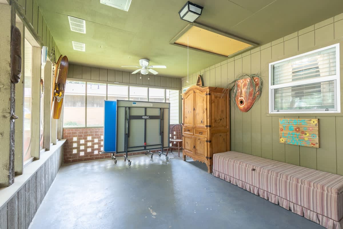 Screened in patio with ping pong table.