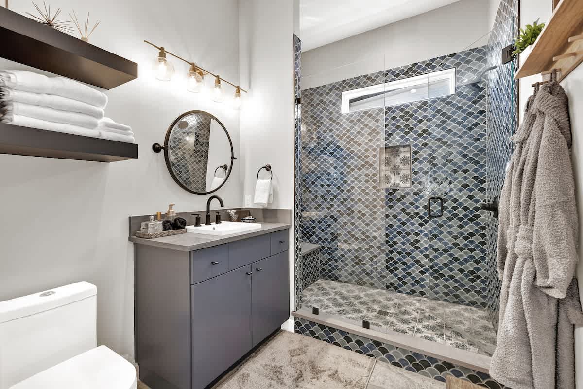 The bathroom has an elegantly tiled spacious walk-in shower.