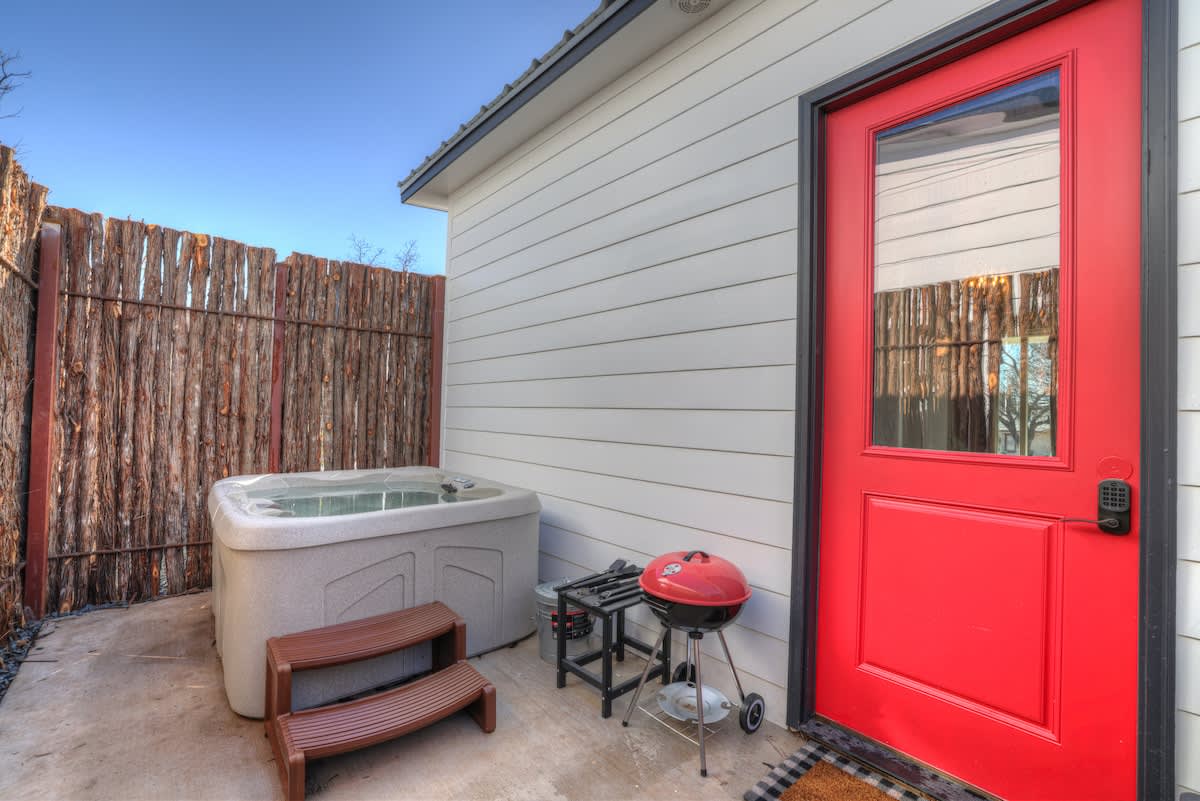 Private hot tub on the back porch with grill.