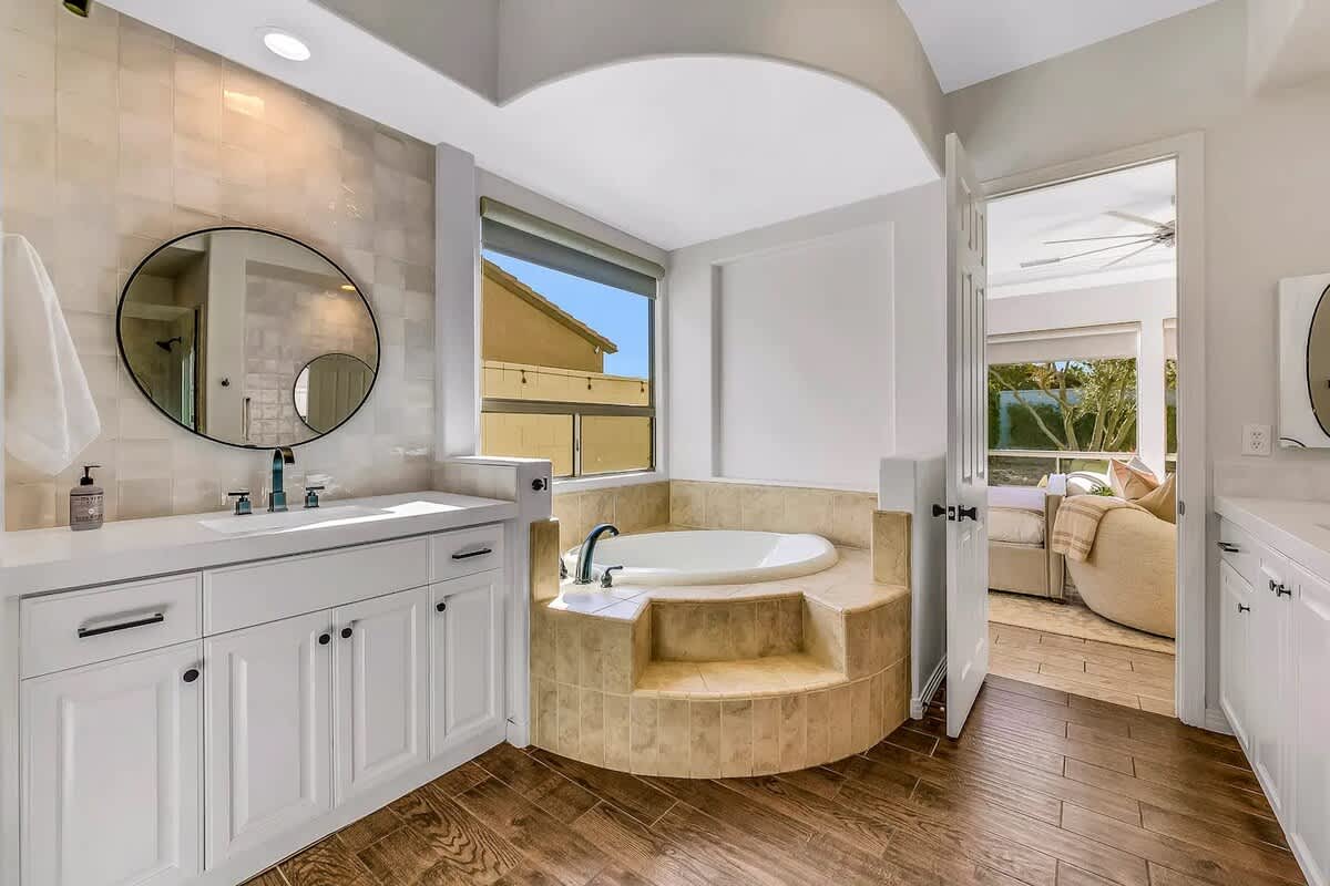 Spa-inspired ensuite with soaking tub, vanity area, and expansive window views.