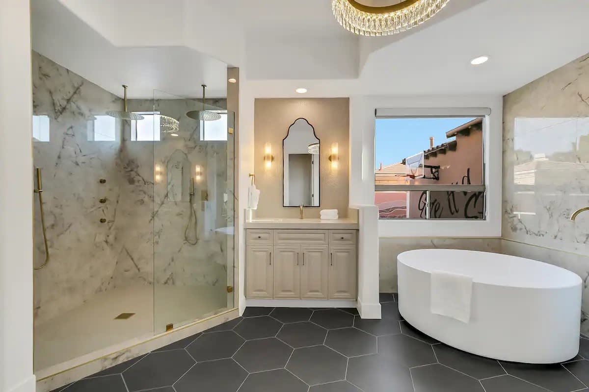 Chic primary bathroom with sleek finishes, glass shower enclosure, and a deep Japanese soaking tub for relaxation.