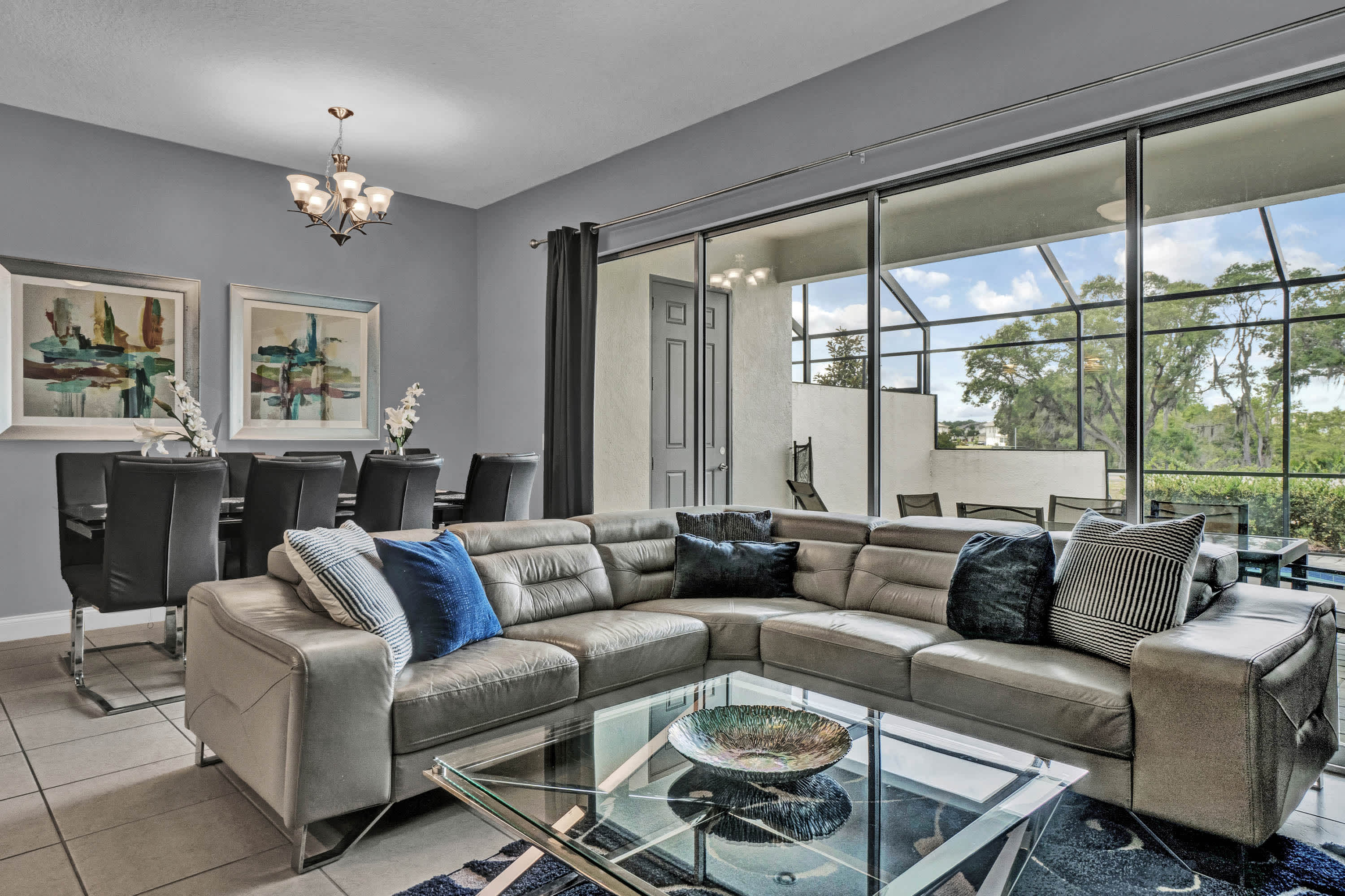 Open living space with large sofa, TV, and back patio access