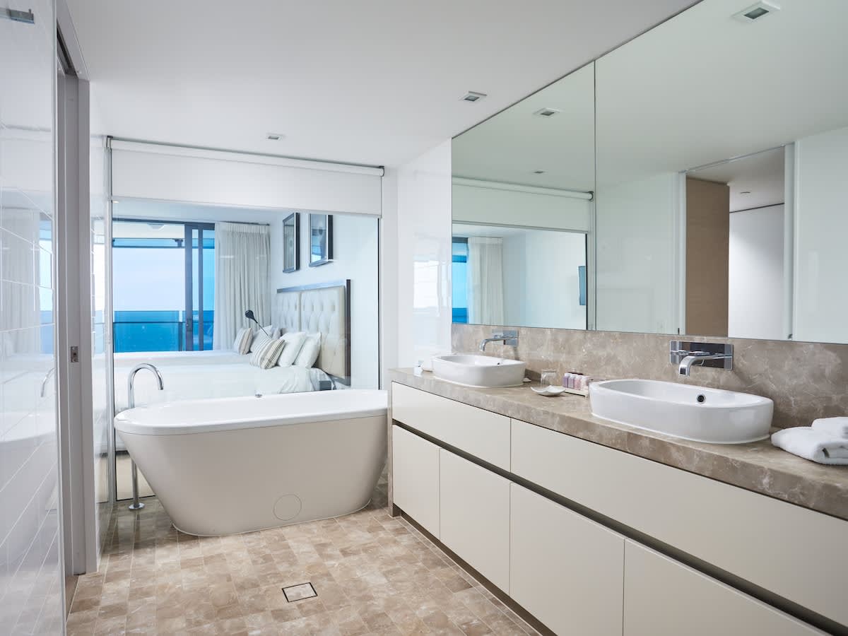 Bedroom 3 ensuite with deep soaking bath, and separate shower. Finished with marble counter tops, dual basins, and stainless steel tapware. Located level 42. 