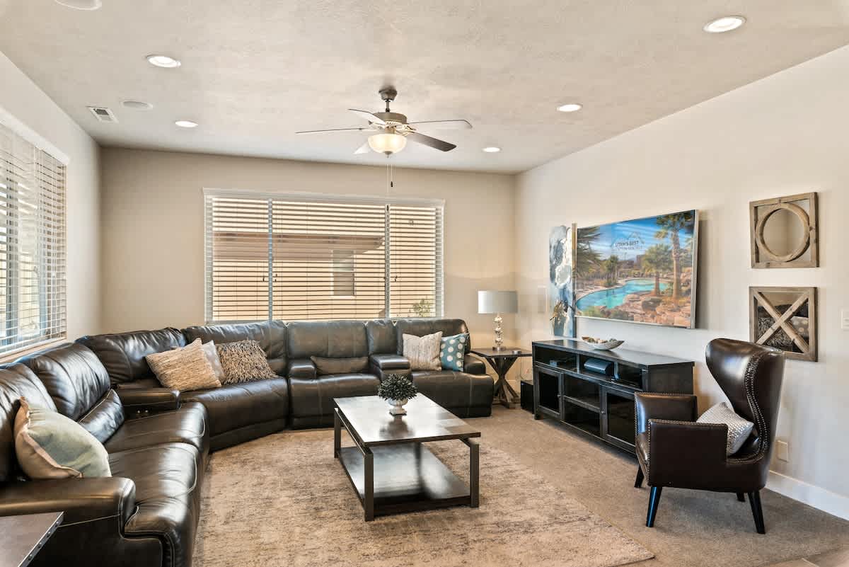 Living room adjacent to kitchen with leather sectional and TV