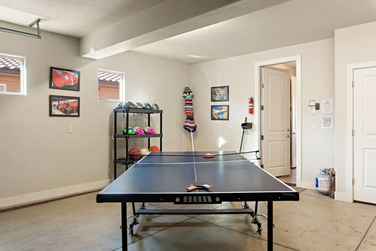 Garage with ping pong table, bikes, and play equipment