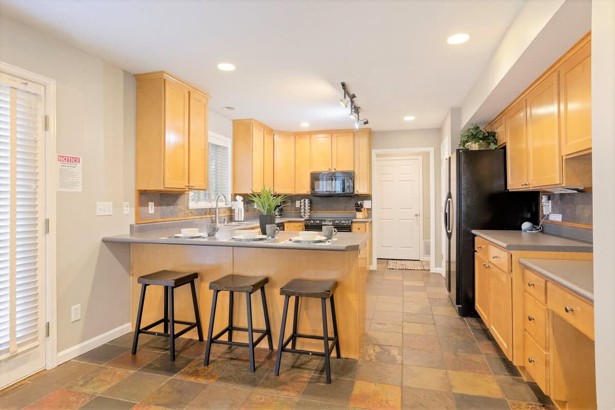 Beautiful full kitchen with bar seating for 3 and slate tile flo