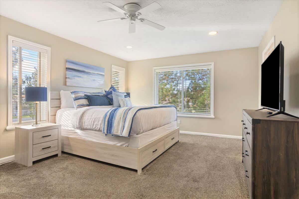 Master bedroom with king bed, dresser, TV and sofa