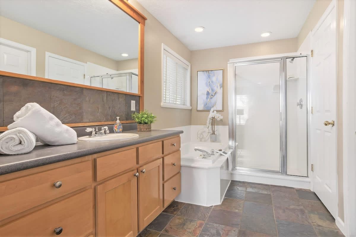 Master bathroom with tub, shower, and sink with walk-in closet