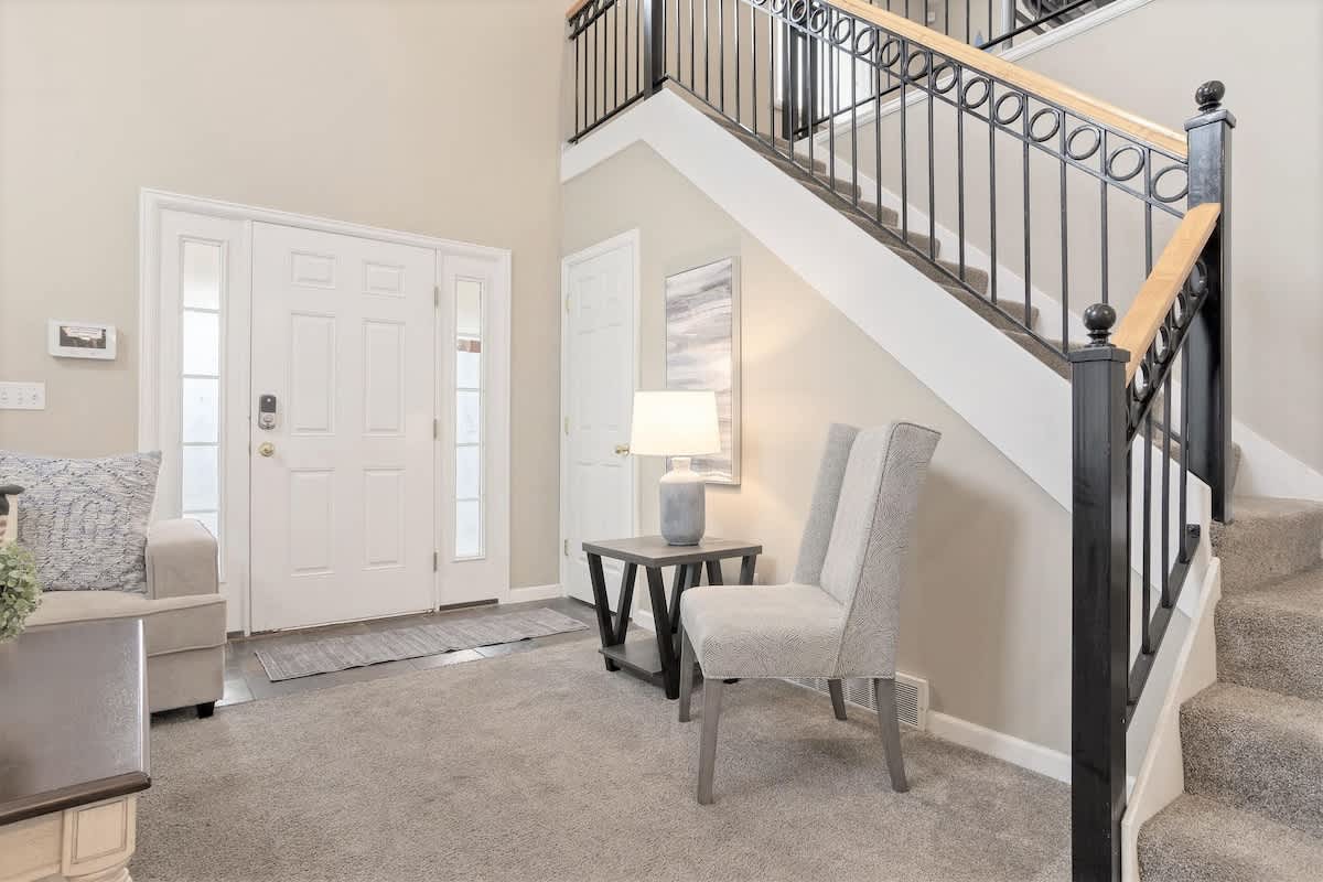 Great room with additional chair and open stairwell to loft