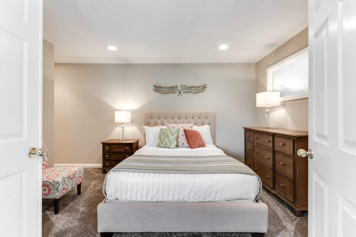 Upstairs, queen bed, dresser, and TV with double door entry
