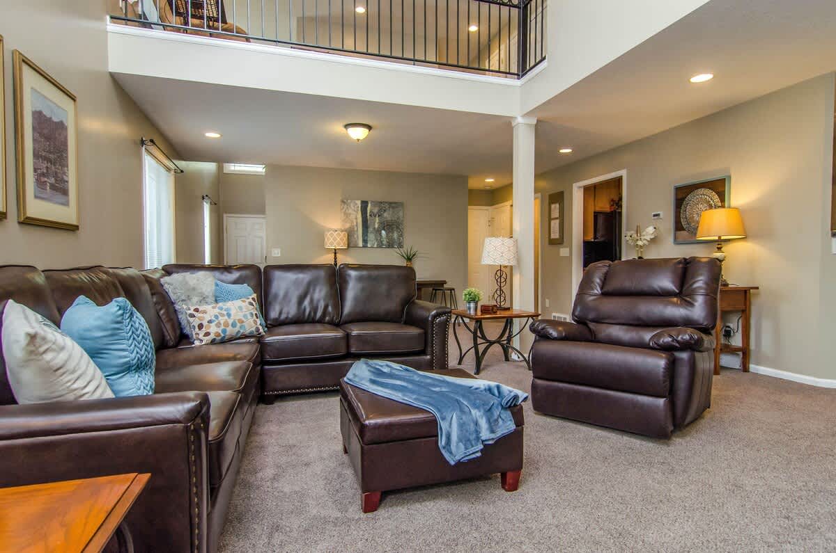 Open spacious family room with balcony and leather sectional