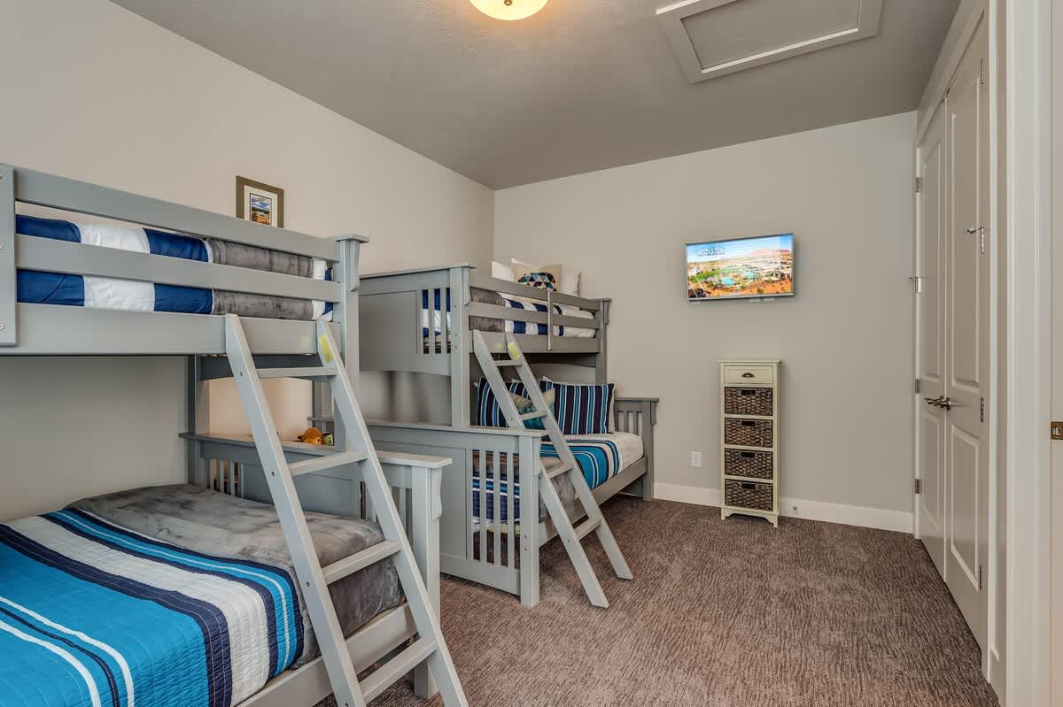 Bunk bedroom upstairs with 2 twin over full bunk beds and TV