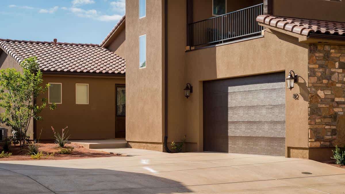 Front exterior with 2-car garage entrance with upper balcony