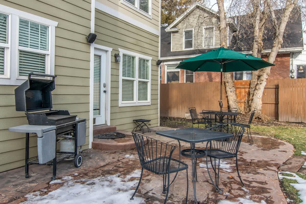 Private back patio with dining set and BBQ in fenced yard