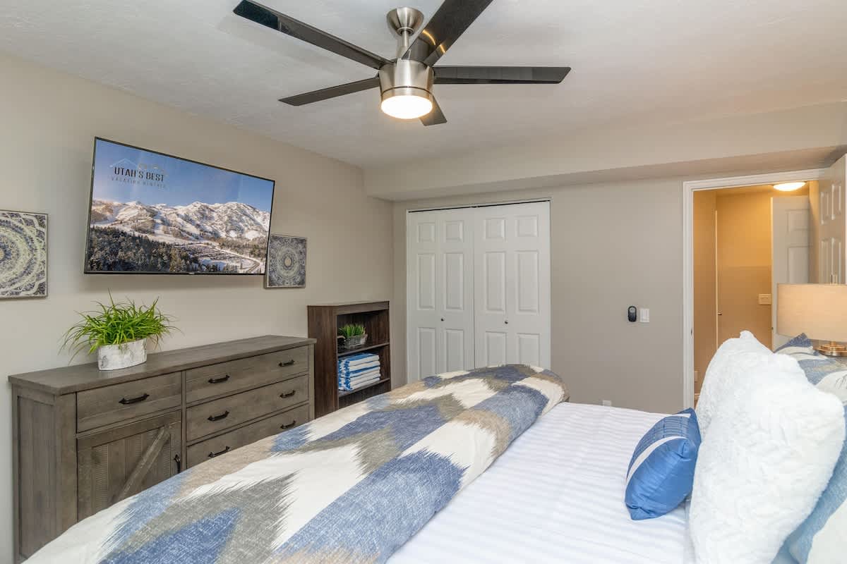 Bedroom 2 with king bed, TV, dresser and ceiling fan
