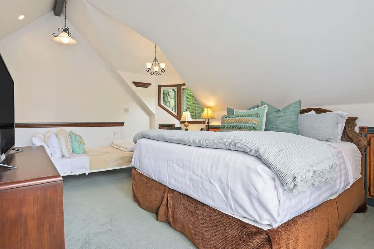 King bed with premium bedding and vaulted ceiling