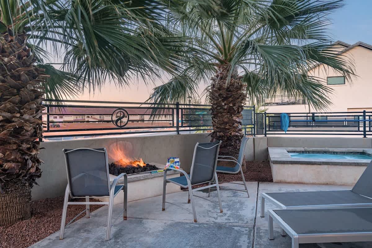 Back patio has outdoor dining, pool, hot tub, and fire pit