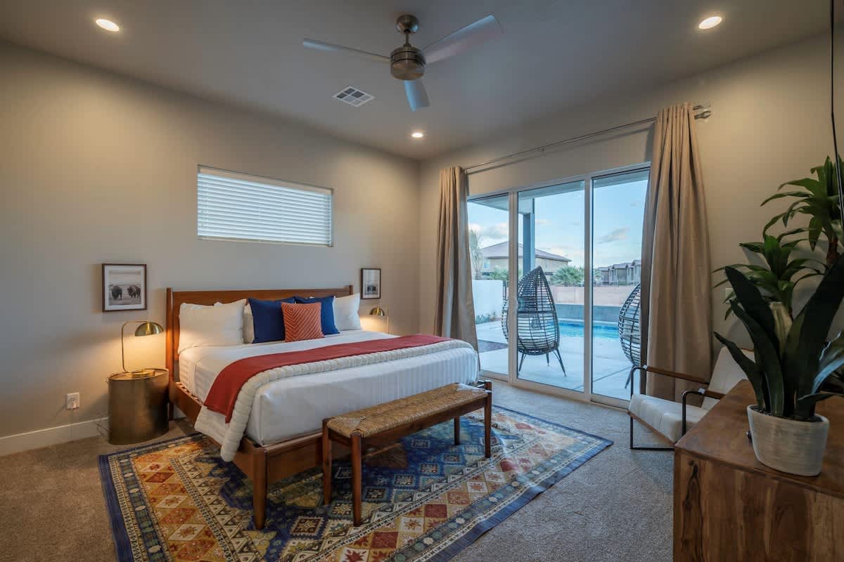 Master bedroom with king bed on main floor with poolside patio