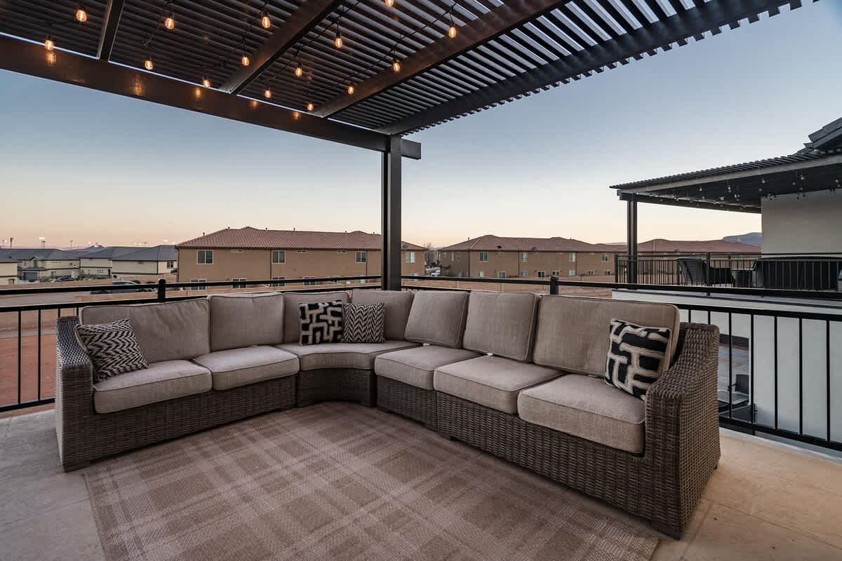 Patio balcony with cushioned sectional sofa and pergola covering