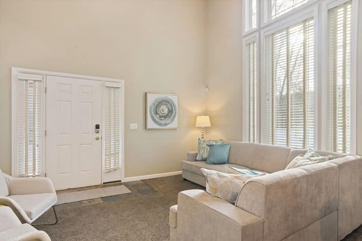 House 1 open great room with sectional and 30-foot windows