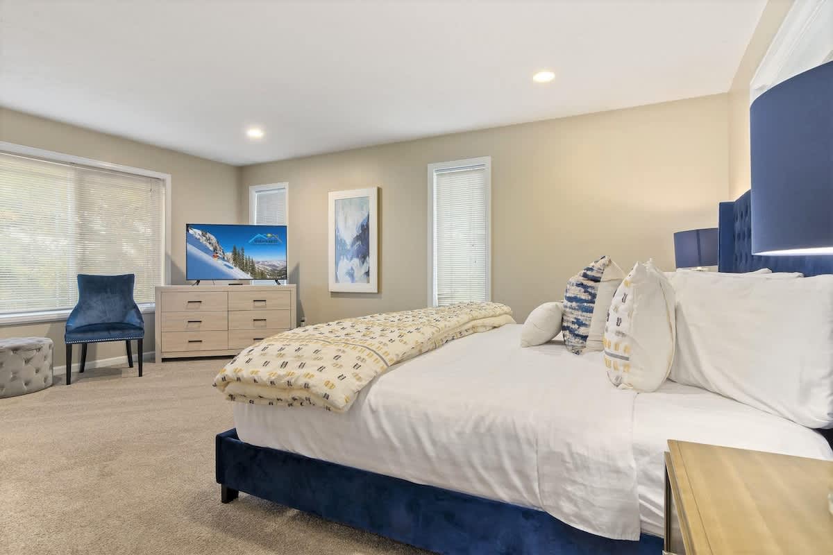 House 2 master bedroom with king bed, dresser, TV, 2 chairs