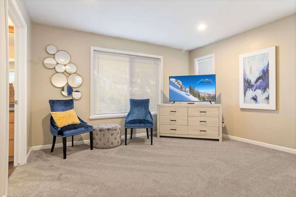 House 2 master bedroom sitting area with 2 chairs and ottoman