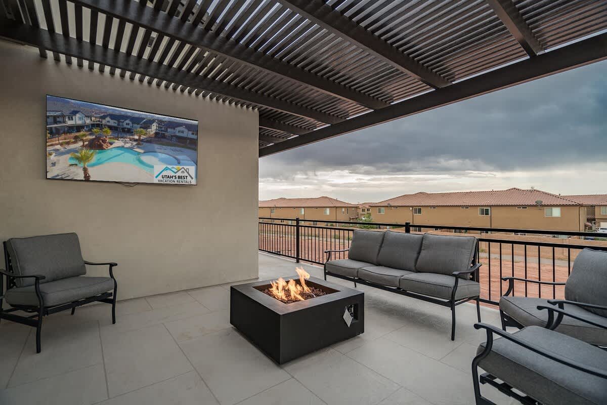 Balcony off family room with fire pit, TV, and pergola covering