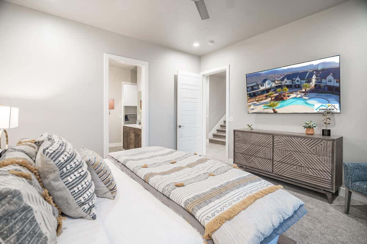 Master bedroom with king bed and large 72-inch smart TV