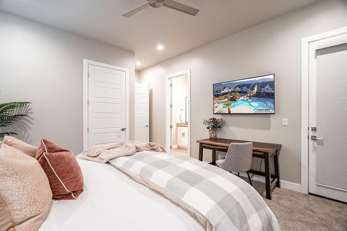 Bedroom 4 has a small desk and large TV