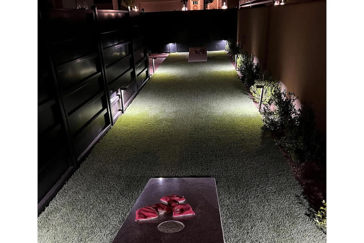Private custom cornhole court nestled on the side of the home