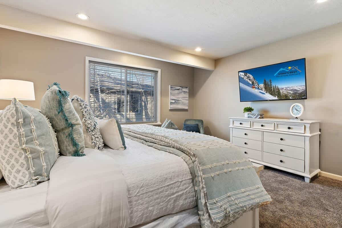 Gorgeous master bedroom with dresser and large TV