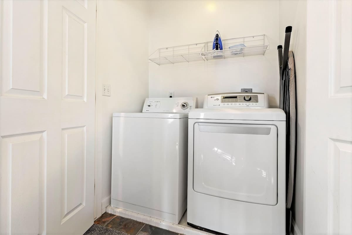 Laundry closet upstairs wtih washer and dryer with ironing board