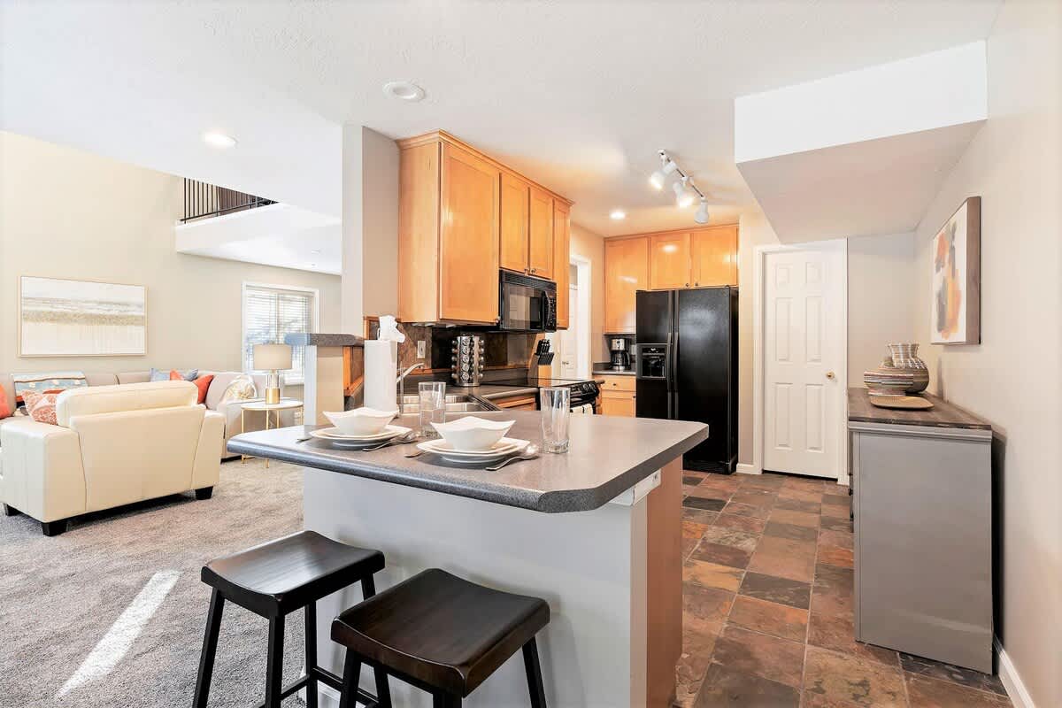 Full kitchen with bar seating in Union Crossroads home