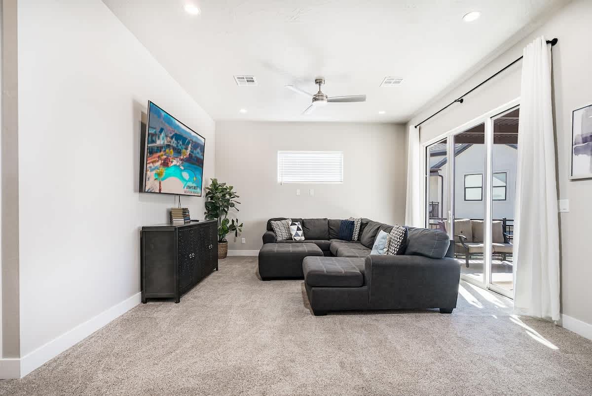 Upstairs family room with sectional, TV and balcony access