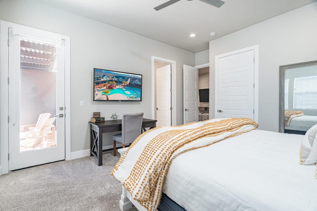 Gorgeous master bedroom with king bed, TV, and balcony access