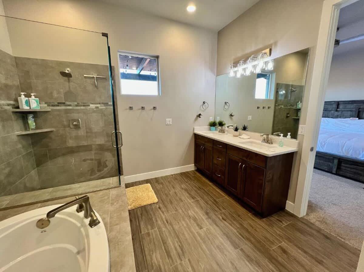 Master bathroom with dual sink vanity, shower and tub