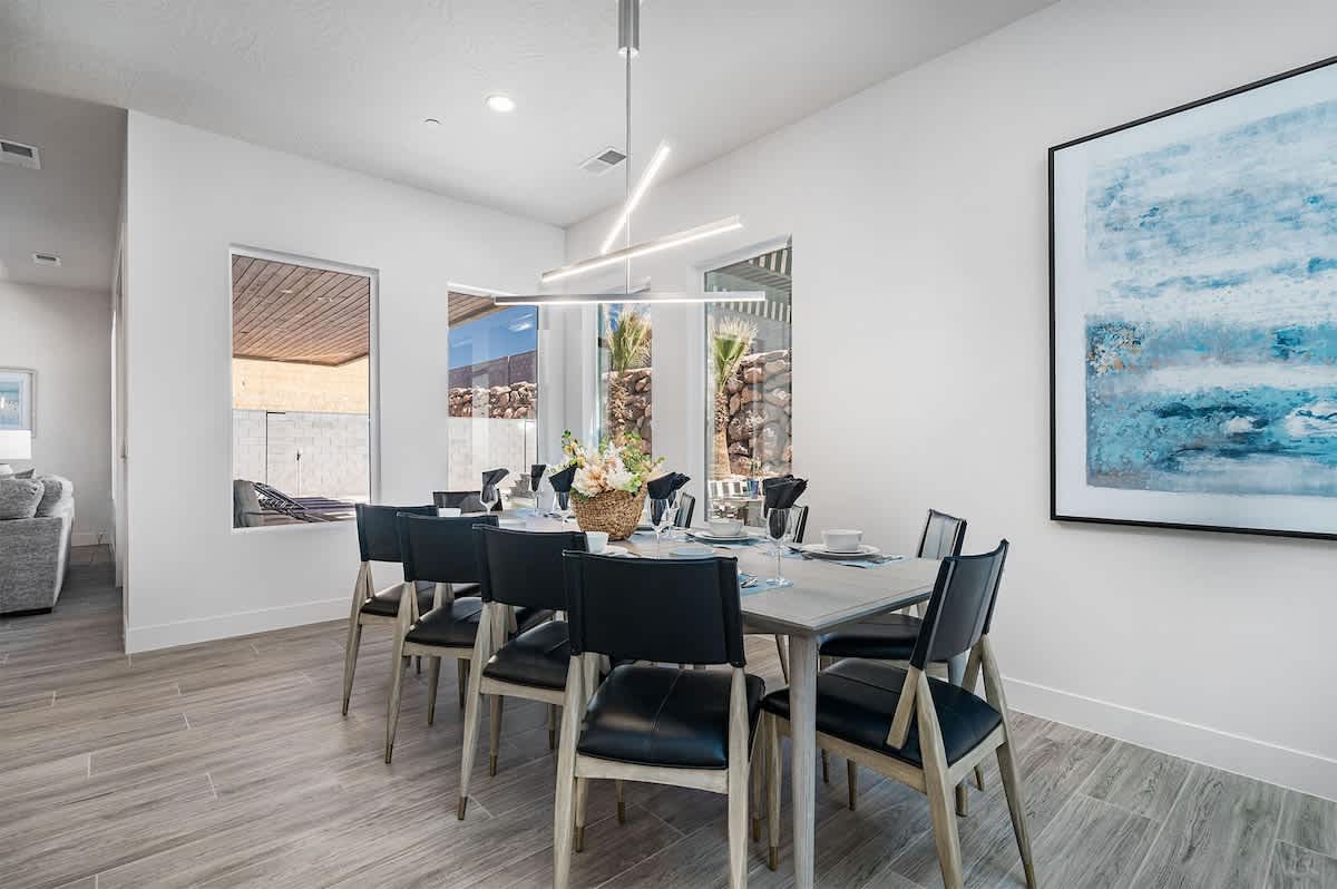 Dining table with large windows looking onto the poolside patio
