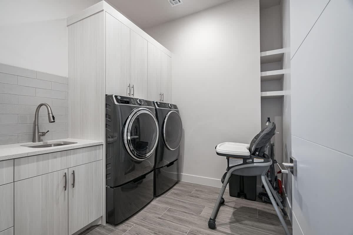Laundry room with front-loading washer/dryer and high chair 