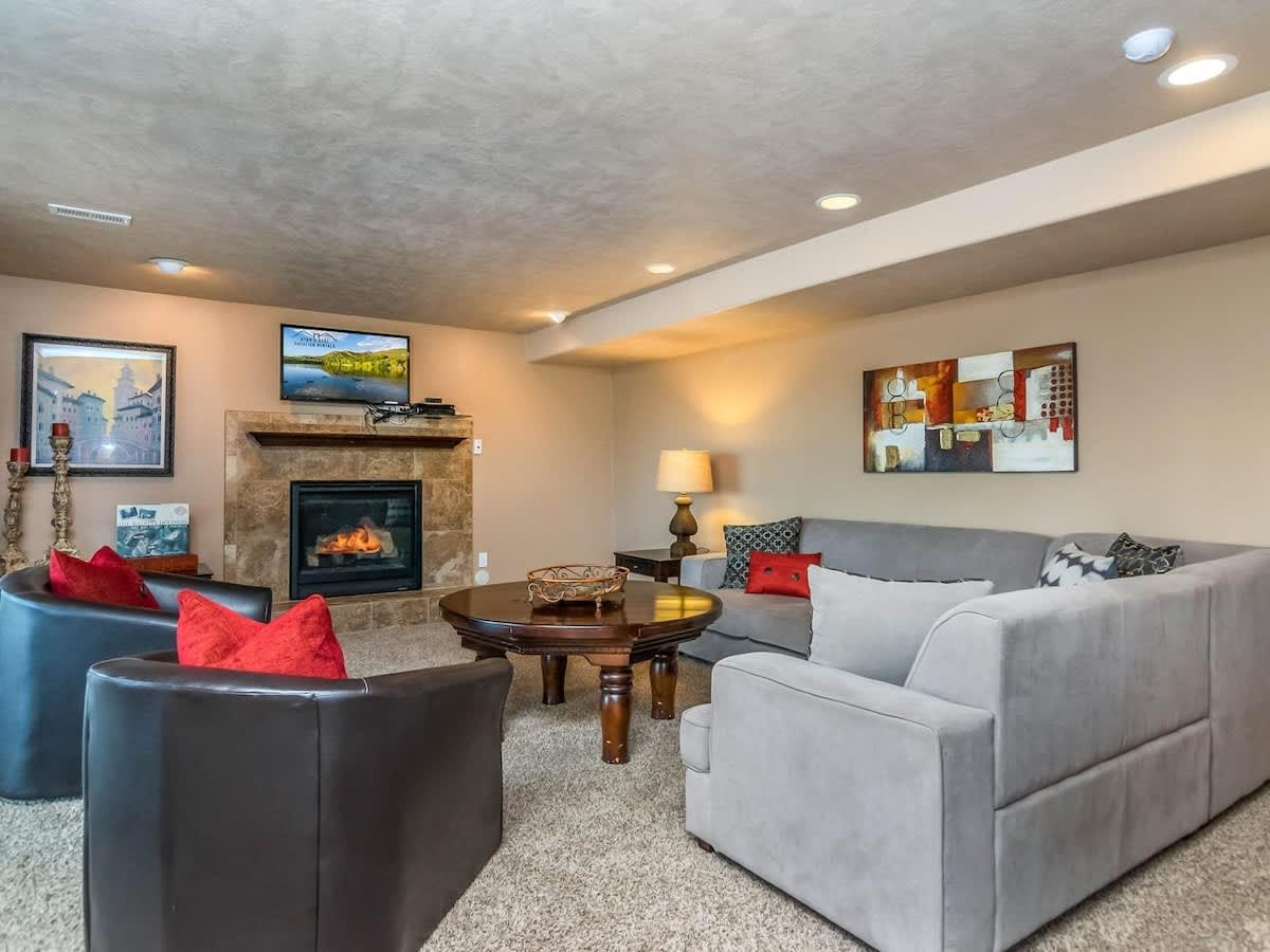  Basement recreation room with fireplace, TV, large sofa and gam