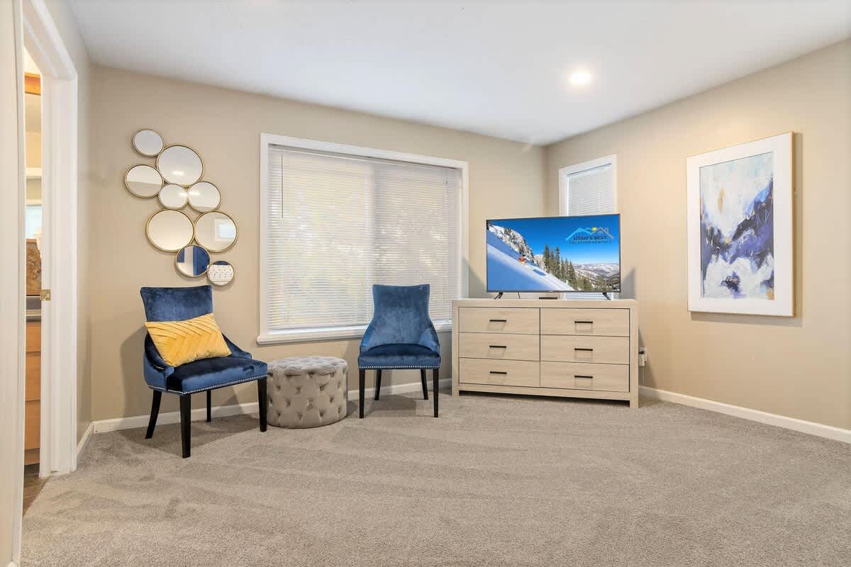 House 2 master bedroom sitting area with 2 chairs and ottoman