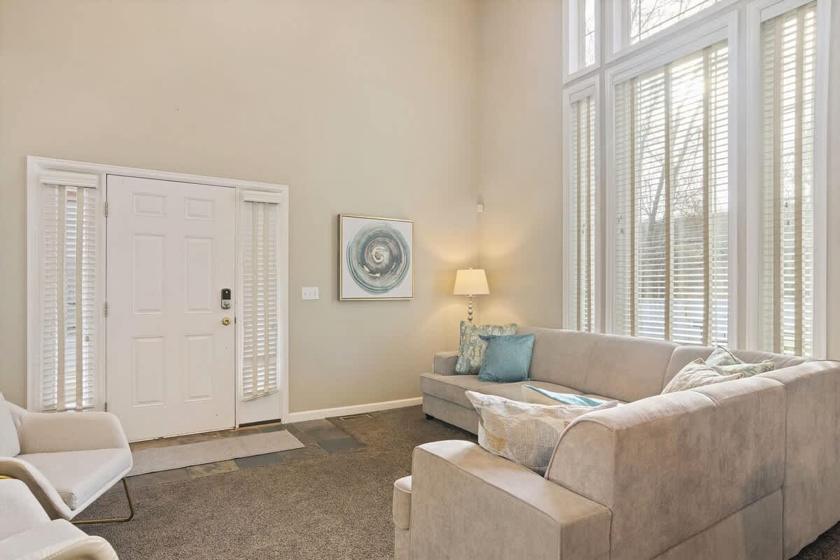 House 1 open great room with sectional and 30-foot windows