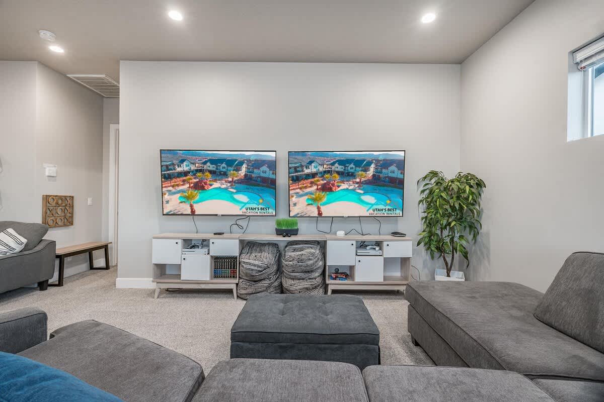 Upstairs family room with large sofa, sofa sleeper, and two TVs