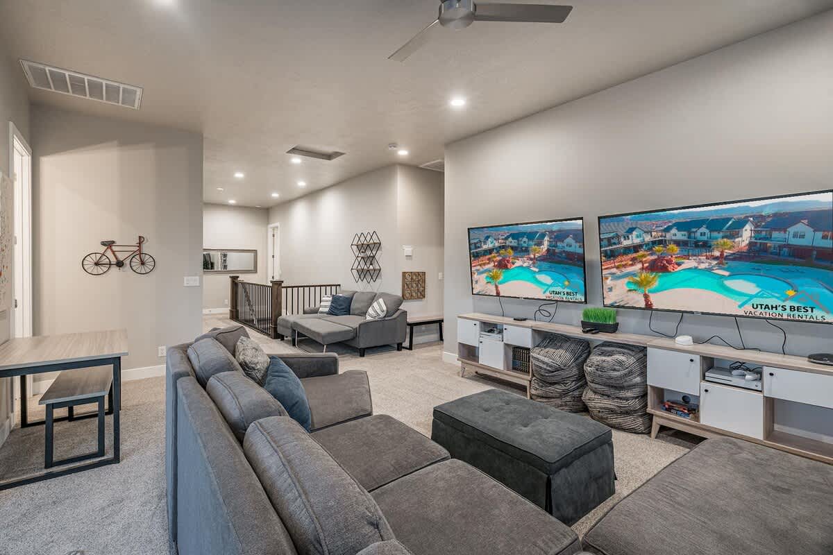 Upstairs family room with large sofa, sofa sleeper, and two TVs