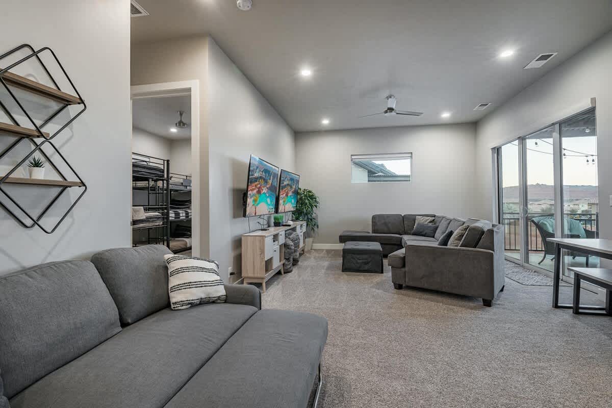 Upstairs family room with large sofa, sofa sleeper, and two TVs